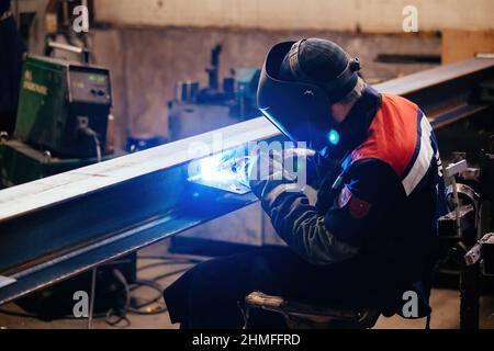 Fabrikarbeiter in Schutzmaske Schweißen Eisenteile, Nahaufnahme. Stockfoto