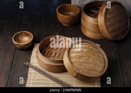 dimsum Korb Bambus Dampfer und Essstäbchen, Holzdarm auf Holztisch Stockfoto
