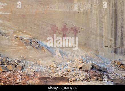 Drei Krieger, die auf einer Canyon-Wand auf dem Wanderweg zu den Lower Calf Creek Falls in Utah gemalt wurden. Stockfoto