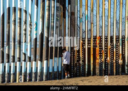 Tijuana, Mexiko. 24th Oktober 2020. Ein Mann steht am Strand von Tijuana neben der Mauer, die Mexiko von den Vereinigten Staaten trennt. (Foto von Antonio Cascio/SOPA Images/Sipa USA) Quelle: SIPA USA/Alamy Live News Stockfoto