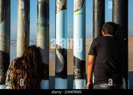 Tijuana, Baja California, Mexiko. 24th Oktober 2020. Ein Mann und eine Frau beobachten die Menschen am Strand von San Diego von der Mauer, die Mexiko von den Vereinigten Staaten am Strand von Tijuana trennt. (Bild: © Antonio Cascio/SOPA Images via ZUMA Press Wire) Stockfoto