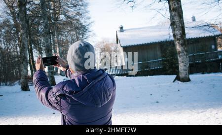 Nahaufnahme eines jungen Mannes, der Selfie im Urlaub im Schnee macht Stockfoto