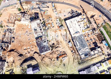 Betonbaustelle mit funktionierenden Kranen und Hochhäusern im Bau. Luftdrohnenfoto. Stockfoto