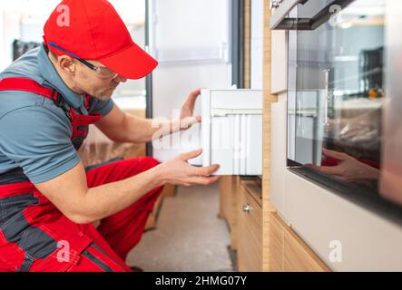 Professionelle Wohnmobil Freizeitfahrzeug Techniker Arbeiter in seinem 40s Reparatur Wohnmobil Wohnmobil Wohnmobil Van Elektro-Kühlschrank. Wohnmobil-Haushaltsgeräte. Stockfoto