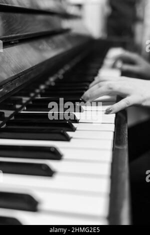 Klaviertasten aus der Nähe. Musikinstrument in Schwarz-Weiß-Foto. Die Hände eines Klavierspielers sind aus dem Blickfeld geraten. Stockfoto