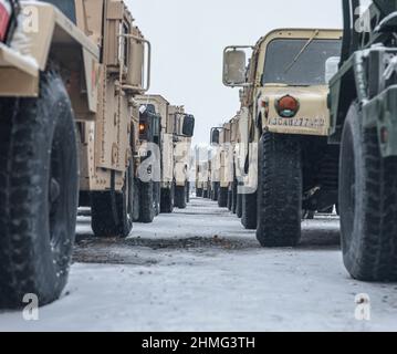 Soldaten der US-Armee, die 10th Combat Aviation Brigade zugewiesen wurden, führen Eisenkopfoperationen auf Fort Drum, NY, am 1. Dezember 2021 durch. Soldaten inszenierten Fahrzeuge auf Pritschenwagen, um zum JRTC nach Fort Polk, La zu fahren. Stockfoto