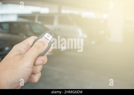 Handhaltetaste auf der Fernbedienung im Hintergrund des Parkplatzes Stockfoto