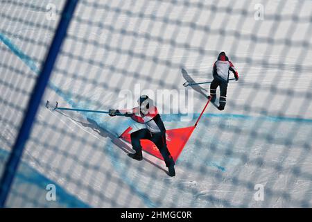 Zhangjiakou, China. 10th. Februar 2022. Olympische Spiele, Snowboardcross, Männer, im Genting Snow Park. Mitarbeiter bereiten den Track vor. Quelle: Angelika Warmuth/dpa/Alamy Live News Stockfoto