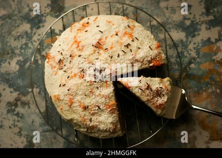 Hausgemachte Karottenkuchen auf einem rustikalen Hintergrund mit einem Stück aus ihm geschnitten Stockfoto