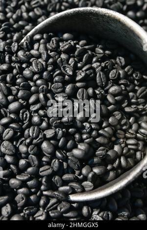 Frisch geröstete aromatische Robusta-Kaffeebohnen in Silberlöffel auf Kaffeebohnen gemahlen. Bio-Kaffee. Lokales Produkt aus Krabi, Thailand. Draufsicht. Stockfoto