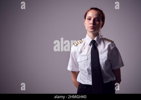 Studio Portrait Von Serious Young Airline Pilot Vor Schlichem Hintergrund Stockfoto