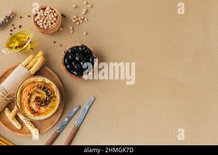 Gesundes Frühstück mit hausgemachtem Hummus, schwarzen Oliven und Knäckebrot. Ernährung und gesunde Snacks. Stockfoto