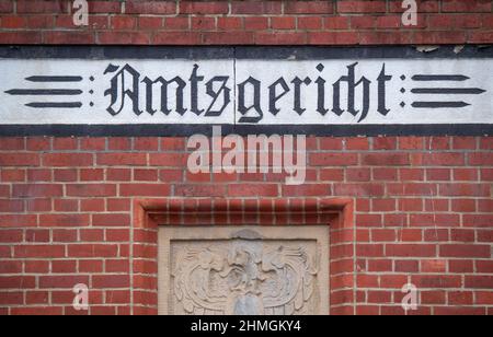 Pasewalk, Deutschland. 10th. Februar 2022. Der Schriftzug „Amtsgericht“ befindet sich auf dem Gebäude des Amtsgerichts in Pasewalk. Das Amtsgericht Pasewalk (Vorpommern-Greifswald) wird am Donnerstag erstmals mit zwei mutmaßlichen Schmugglern verhandeln, die Migranten aus Weißrussland nach Deutschland gebracht haben. Die 38-jährige Frau und der 39-jährige Mann werden von der Staatsanwaltschaft beschuldigt, durch illegalen Schmuggel von Ausländern gegen das Aufenthaltsgesetz verstoßen zu haben. Die beiden polnischen Verdächtigen waren am 18. August 2021 in der Nähe von Löcknitz verhaftet worden. Quelle: Stefan Sauer/dpa/Alamy Live News Stockfoto