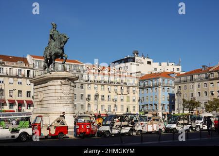 Lissabon, Portugal - 17 2021. November: Tuk-Tuk-Fahrer warten auf Touristen an der Statue des Dom Joao I auf dem Figueira-Platz im historischen Zentrum von Lissabon auf einer Stockfoto