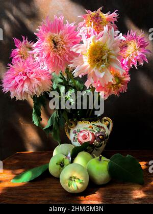 Romantisches Bouquet von Dahlien und Quitte in einer dekorativen Keramikvase in den Strahlen des Sonnenlichts Stockfoto