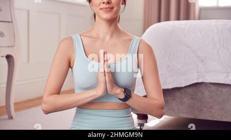 Nahaufnahme Einer Frau, Die Im Schlafzimmer Zu Hause Yoga Macht Und Fitnesskleidung Und Aktivitätsmonitor Trägt Stockfoto