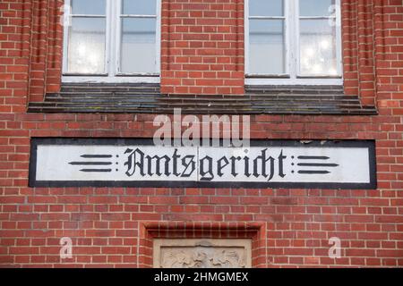 Pasewalk, Deutschland. 10th. Februar 2022. Der Schriftzug „Amtsgericht“ befindet sich auf dem Gebäude des Amtsgerichts in Pasewalk. Das Amtsgericht Pasewalk (Vorpommern-Greifswald) wird am Donnerstag erstmals mit zwei mutmaßlichen Schmugglern verhandeln, die Migranten aus Weißrussland nach Deutschland gebracht haben. Die 38-jährige Frau und der 39-jährige Mann werden von der Staatsanwaltschaft beschuldigt, durch illegalen Schmuggel von Ausländern gegen das Aufenthaltsgesetz verstoßen zu haben. Die beiden polnischen Verdächtigen waren am 18. August 2021 in der Nähe von Löcknitz verhaftet worden. Quelle: Stefan Sauer/dpa/Alamy Live News Stockfoto