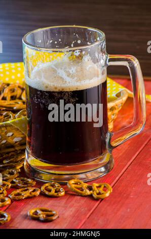 Pint dunkles Bier und salzige Snacks Stockfoto