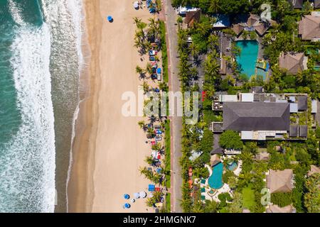 Blick von oben auf den berühmten Strand von Kuta in Seminyak im Süden von Bali mit luxuriösem Strandresort in Indonesien Stockfoto
