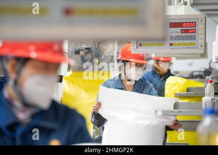 BAZHOU, CHINA - 10. FEBRUAR 2022 - Arbeiter verkapseln Dünger in der Fertigproduktverpackungswerkstatt der sinopec Niederlassung in Bozhou, Xinjiang PR Stockfoto