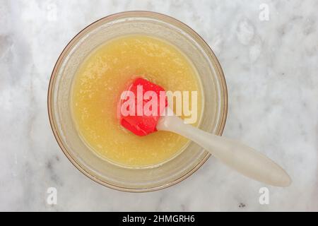 Draufsicht auf Honigteig für Kuchen medovik und Spatel auf Marmorhintergrund Stockfoto