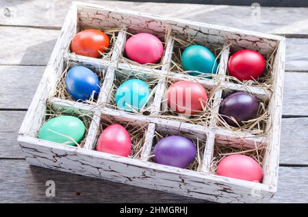 Ostereier in einer Holzkiste mit Heu bei Tageslicht Stockfoto