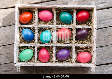 Ostereier in einer Holzkiste mit Heu bei Tageslicht Stockfoto