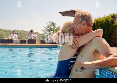 Liebevolles Rentnerpaar Umarmt Am Swimmingpool Im Sommerurlaub Stockfoto