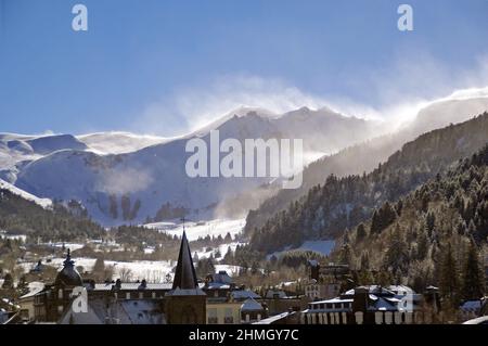 Die Stadt Mont-Dore, mit Schneeverwehungen über dem Massif de Sancy Stockfoto