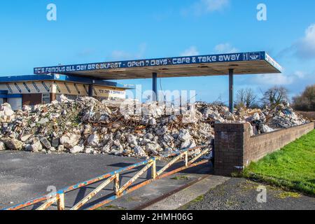 Trümmerblockade am Vorplatz und Café der stillgelegten Tankstelle; große Blöcke vor freiem Land in Tarleton, Großbritannien. Stockfoto