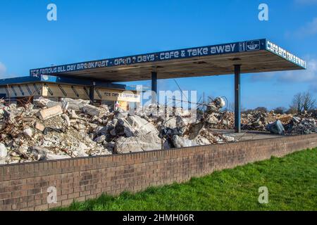 Trümmerblockade am Vorplatz und Café der stillgelegten Tankstelle; große Blöcke vor freiem Land in Tarleton, Großbritannien. Stockfoto