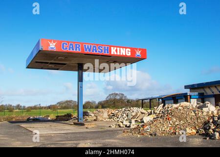 Trümmerblockade am Vorplatz und Café der stillgelegten Tankstelle; große Blöcke vor freiem Land in Tarleton, Großbritannien. Stockfoto