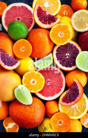 Nahaufnahme von frischen, saftigen Zitrusfrüchten - Orangen, Mandarinen, Zitronen und Limetten, Draufsicht Stockfoto