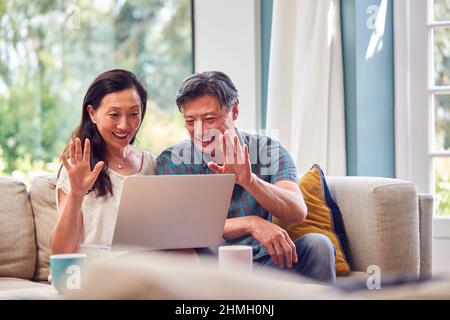 Reifes Paar Sitzt Auf Sofa Zu Hause Machen Videoanruf Auf Laptop Stockfoto