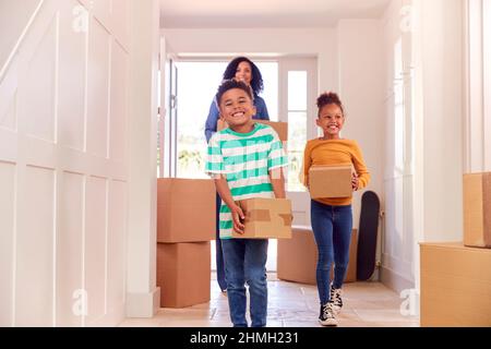Kinder Helfen Mutter, Kisten In Das Neue Zuhause Zu Tragen, Wenn Sie In Den Tag Umziehen Stockfoto
