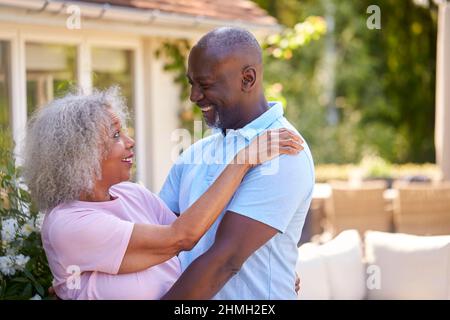 Liebevolles Senioren-Rentnerpaar Umarmt Sich Im Garten Zu Hause Stockfoto