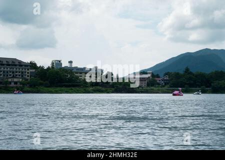 Schwanenboot mit Gebäuden im Hintergrund auf dem Kawaguchi-See in Yamanashi in der Nähe des Fuji-Berges, Japan Stockfoto