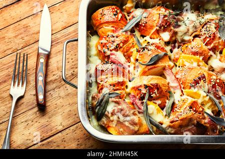 Gebackene Croissants mit Käse, Speck, gekochtem Schweinefleisch und Salbei. Stockfoto