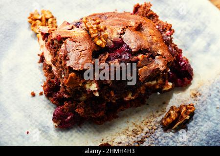 Stück Kuchen mit Schokolade, Kirschen und Nüssen. Marmorkuchen. Stockfoto