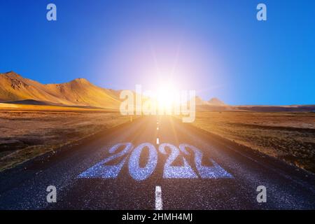 Beginnen Sie das neue Jahr mit neuen Visionen und Ideen. 2022 Nummern auf Asphaltstraße Stockfoto