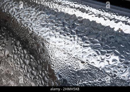 Wassertropfen auf Autoscheinwerfer Stockfoto