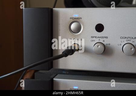 CD-Player auf der Vorderseite mit eingestecktem Kopfhörerkabel und Auswahlknopf für Lautsprecher. Gebürstetes Aluminium. Stockfoto