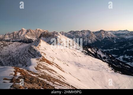 Alpine Berglandschaft an einem kalten Wintertag nach Sonnenuntergang. Blick von den Ammergauer Alpen auf die Zugspitze und die Mieminger-Kette. Tirol, Österreich, Europa Stockfoto