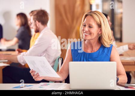 Reife Geschäftsfrau Mit Laptop, Die Im Büro-Café Am Tisch Arbeitet Stockfoto