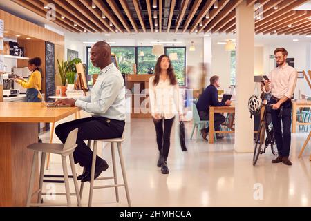 Inneneinrichtung Des Geschäftigen Office Coffee Shops Mit Geschäftsleuten, Die An Tischen Arbeiten Stockfoto