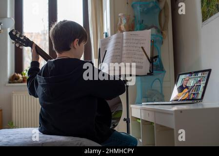 Boy lernt Gitarre im Online-Kurs. Stockfoto