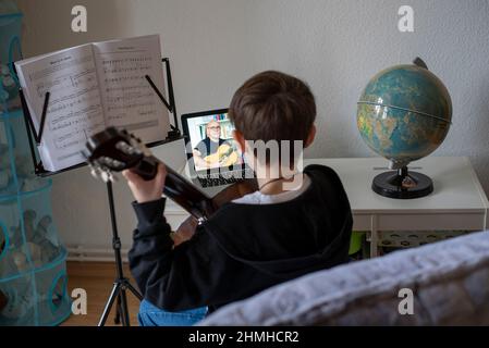 Boy lernt Gitarre im Online-Kurs. Stockfoto