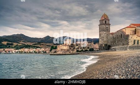 ANSA de la Baleta in Collioure. Die Kirche Notre Dames des Anges auf der rechten Seite wurde Ende des 17. Jahrhunderts erbaut. Die Château Royal de Collioure, auf der linken Seite, wie die Kirche, ist als Denkmal historique klassifiziert. Die ersten Erwähnungen stammen aus dem VII. Jahrhundert. Stockfoto