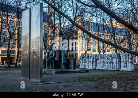 Skulptur von Karl Marx und Friedrich Engels vor Steintafel mit DDR-Geschichte - Marx-Engels-Forum, Berlin Stockfoto