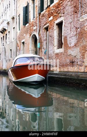 Modernes Motorboot vor einem renovierungsbedürftigen Gebäude in Venedig, Italien Stockfoto